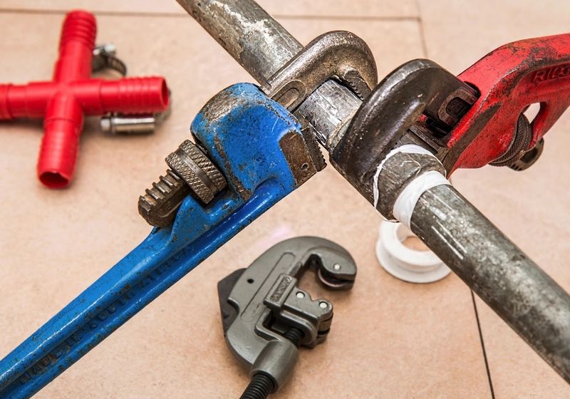 Pipe wrenches and cutting tools on plumbing pipework